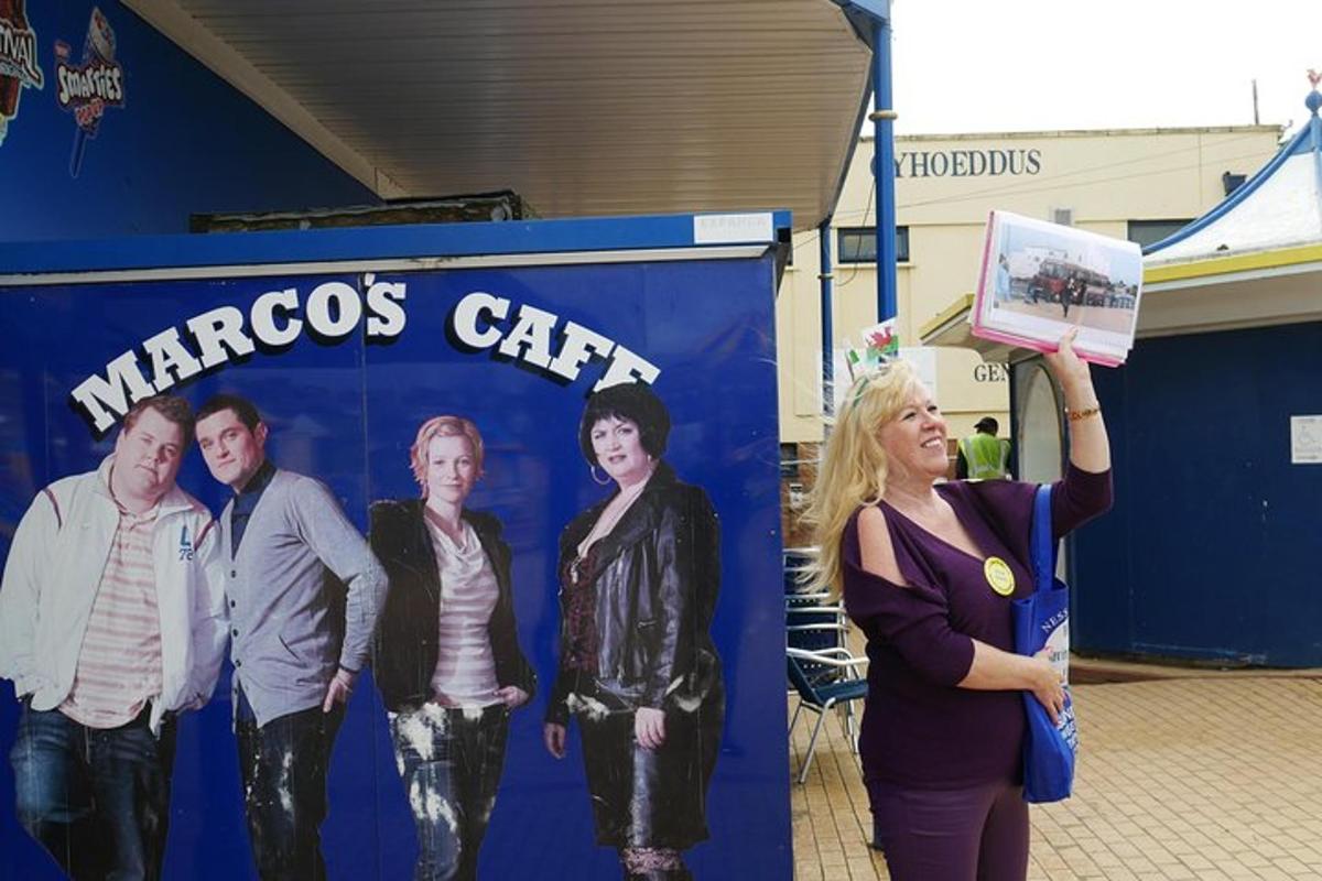 a woman holding up a sign in front of a wall
