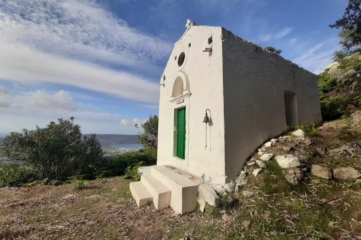 a small building on a hill with a green door