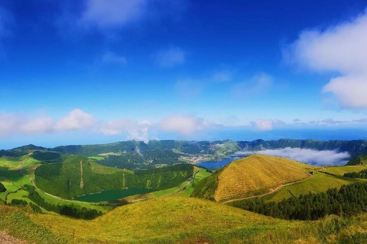 pemandangan lereng bukit hijau dengan awan di latar belakang