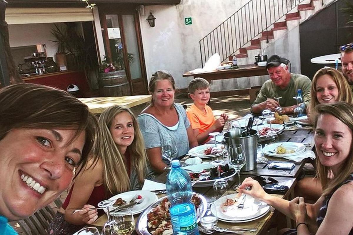grupp inimesi istub laua taga ja sööb