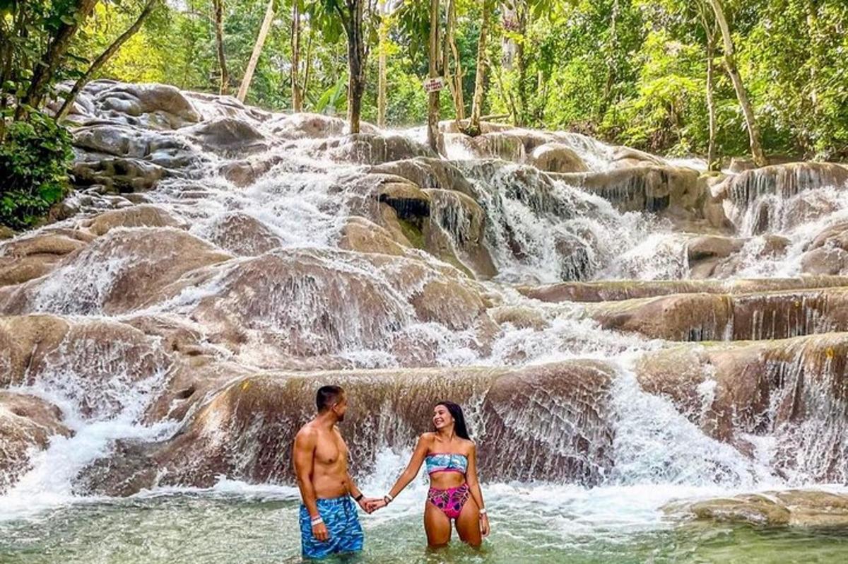 Un hombre y una mujer de pie frente a una cascada