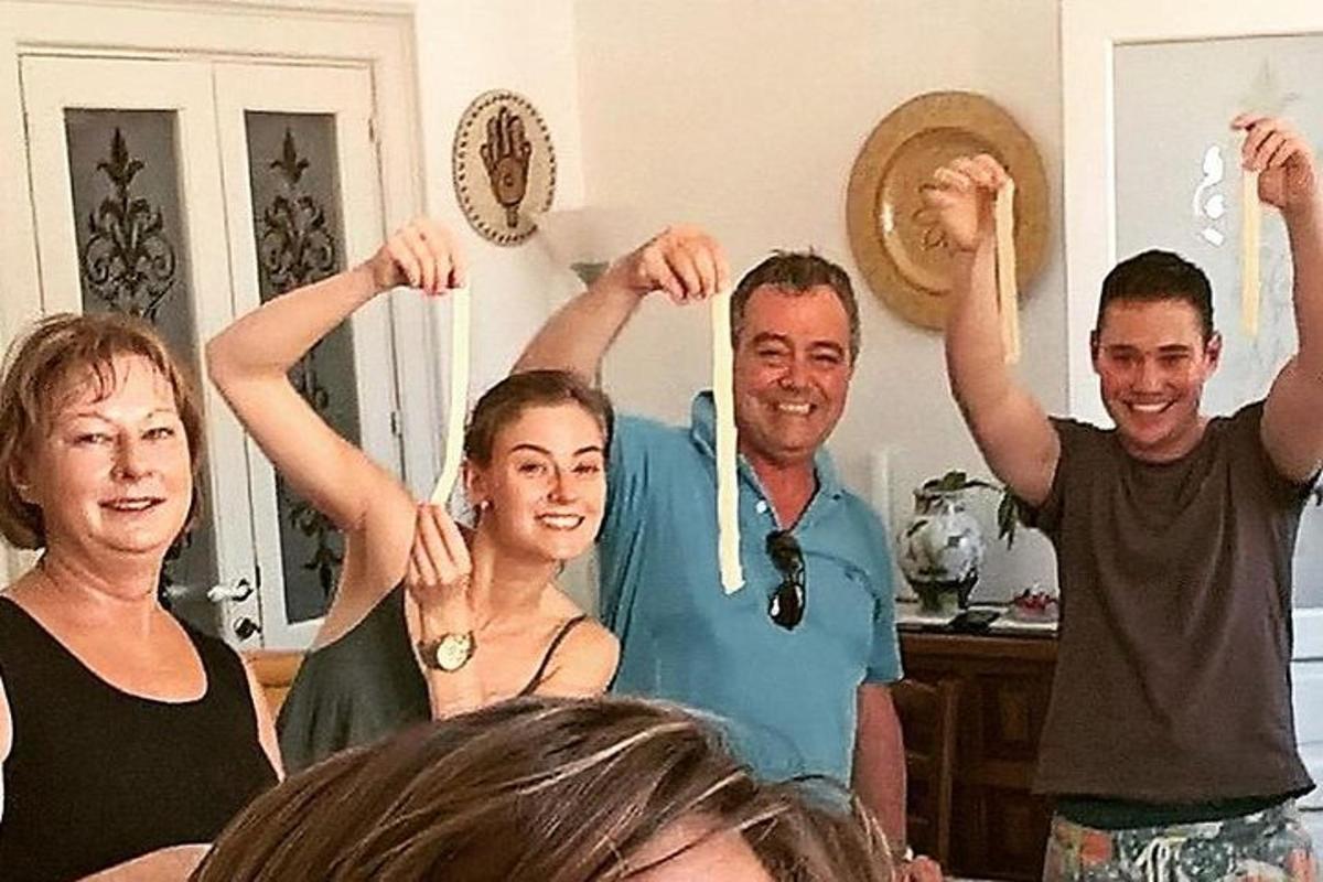 een groep mensen die in een woonkamer staan en omhoogstokken vasthouden