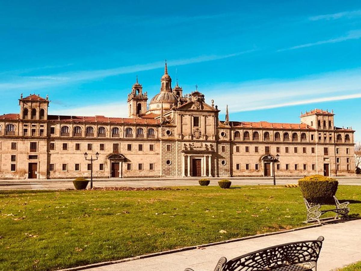 a large building with two chairs in the grass