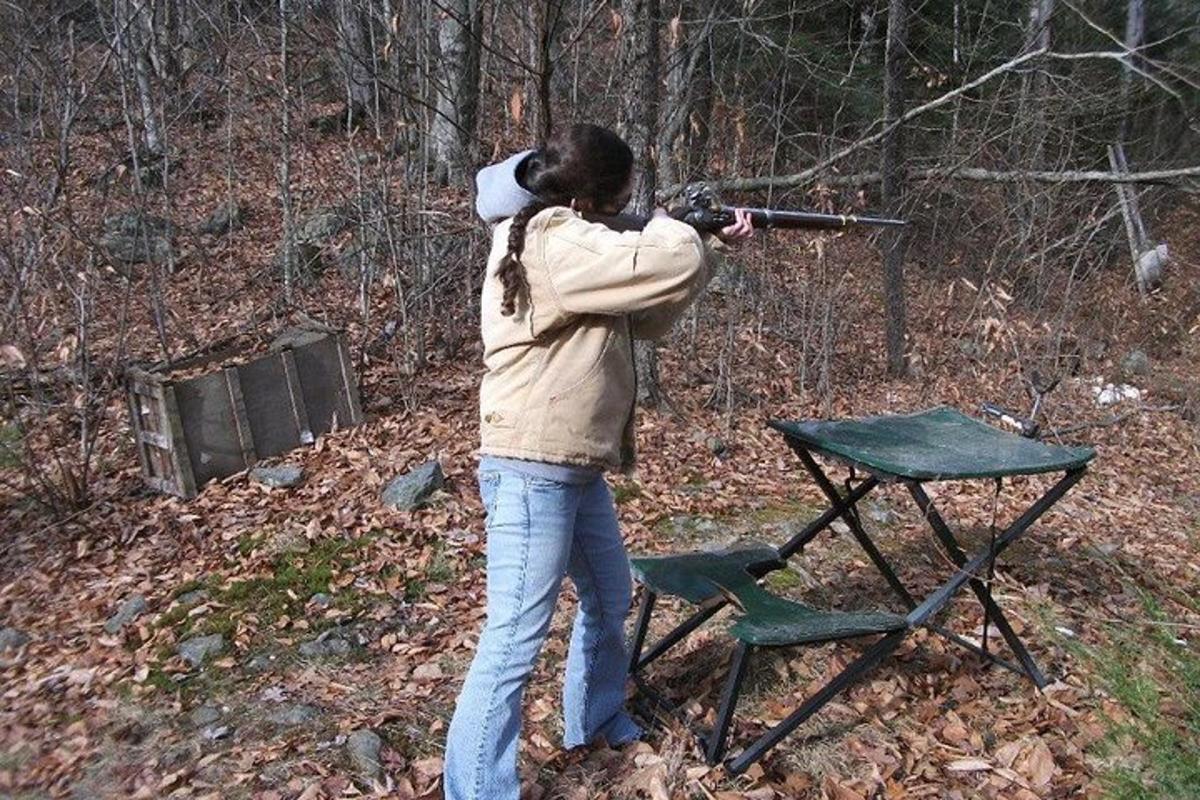 a woman aiming a gun at a table