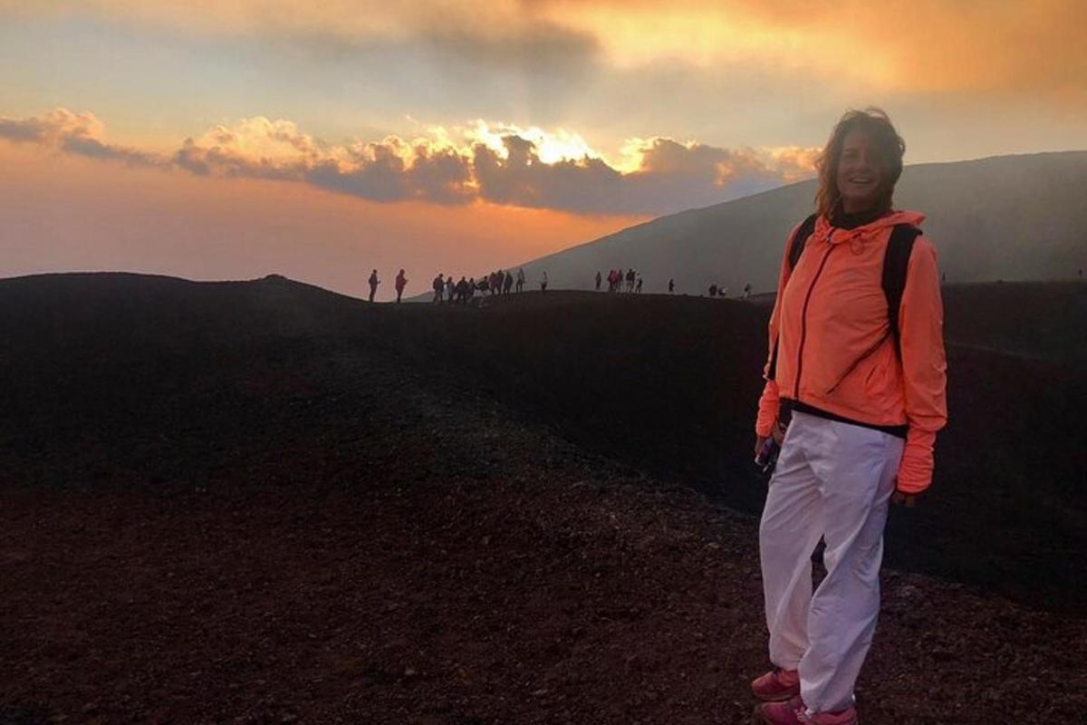 seorang wanita berdiri di puncak gunung