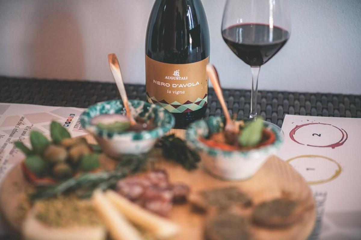 una botella de vino y un plato de comida y una copa de vino