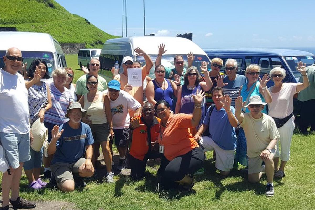a group of people posing for a picture in front of vehicles