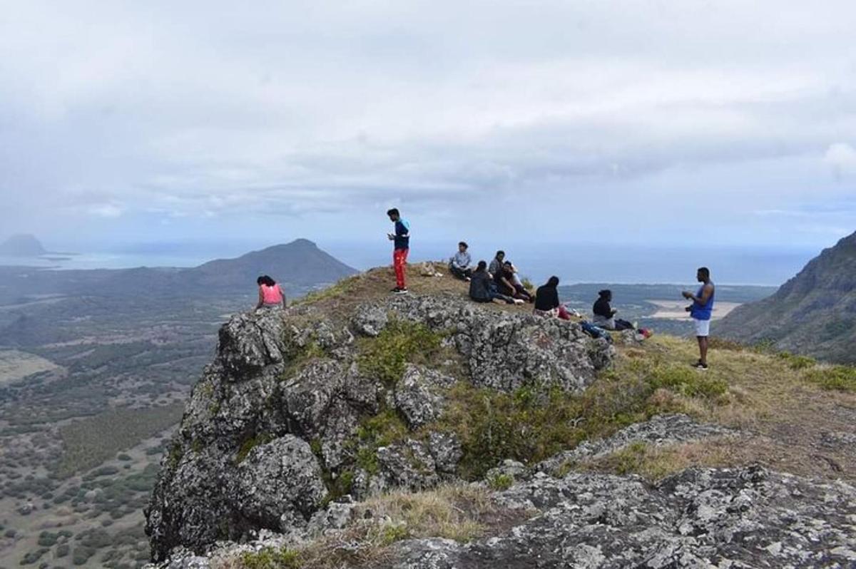 isang grupo ng mga tao na nakaupo sa tuktok ng isang bundok