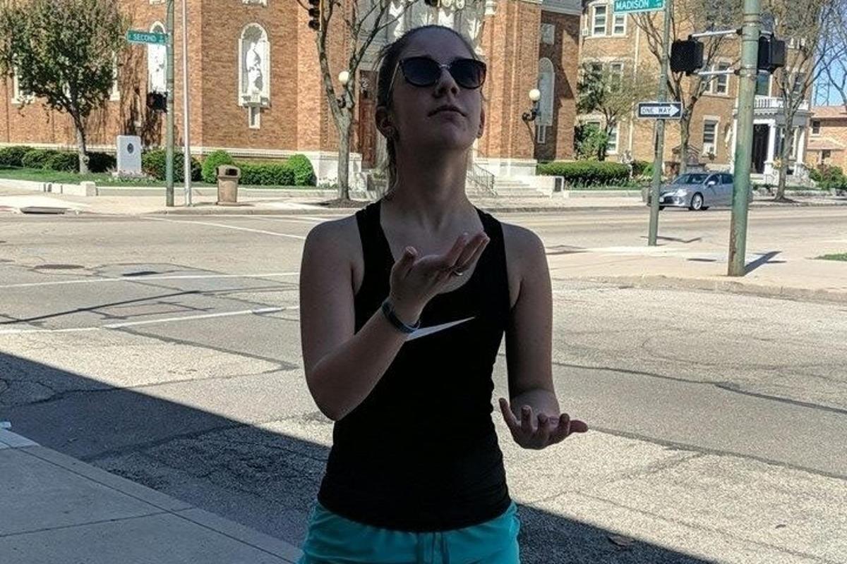 a woman standing on a street with a crosswalk