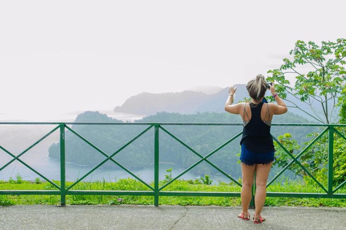 a woman standing on a ledge looking at the water