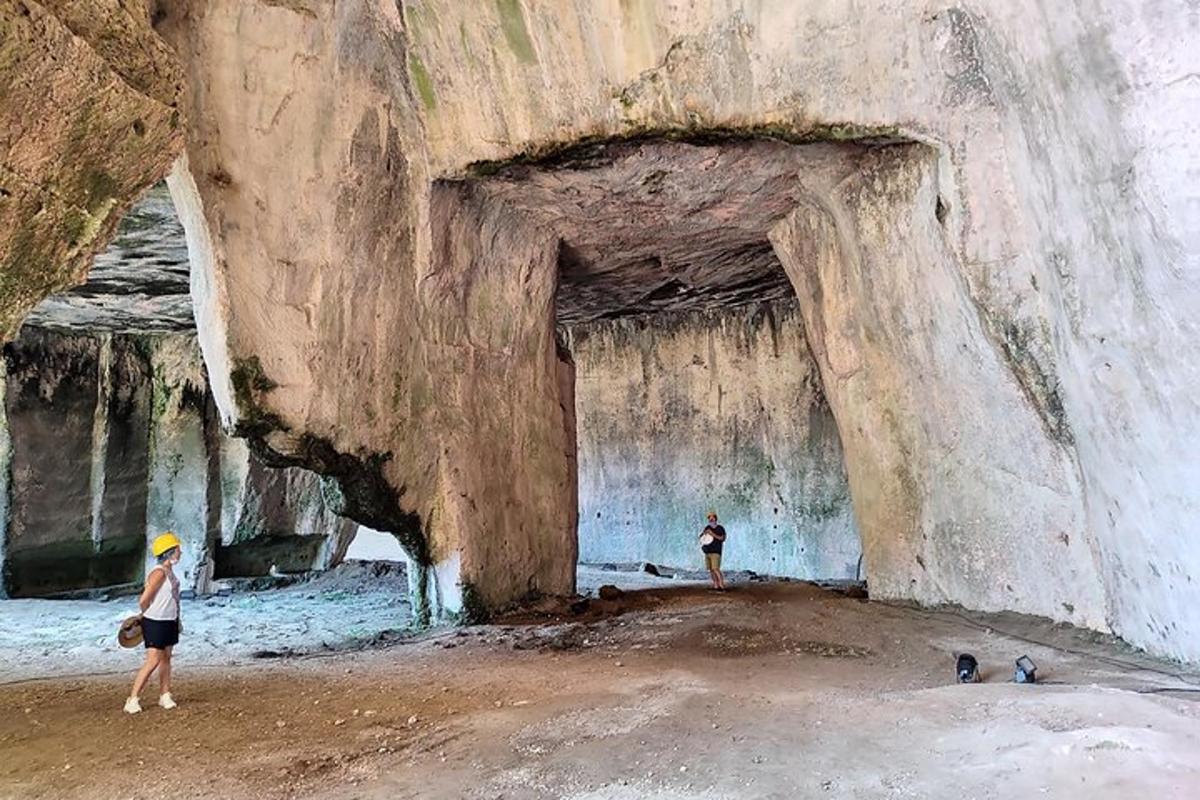 due persone in piedi davanti a una grotta rocciosa