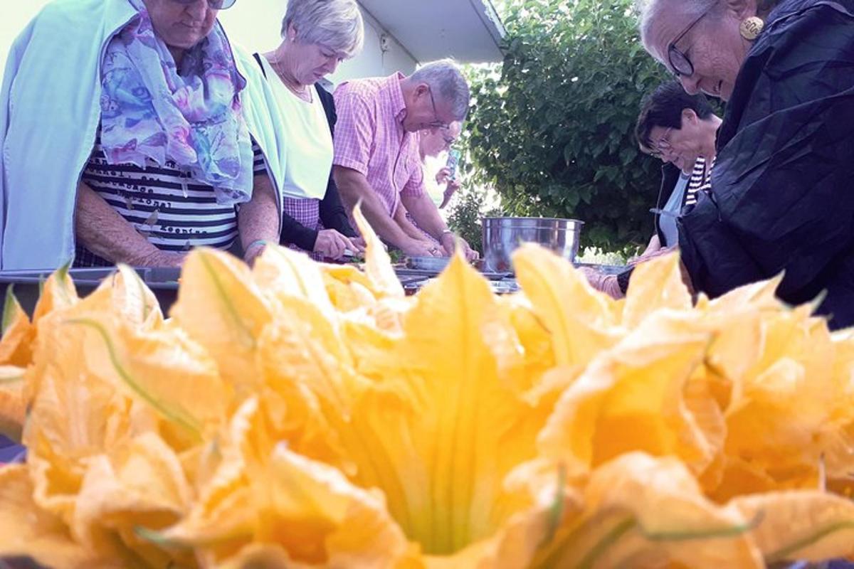 grupp inimesi, kes seisavad laua ümber toiduga
