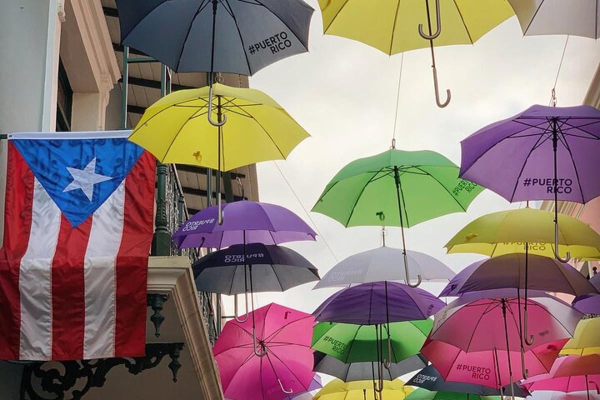 a bunch of umbrellas hanging from the ceiling with a flag