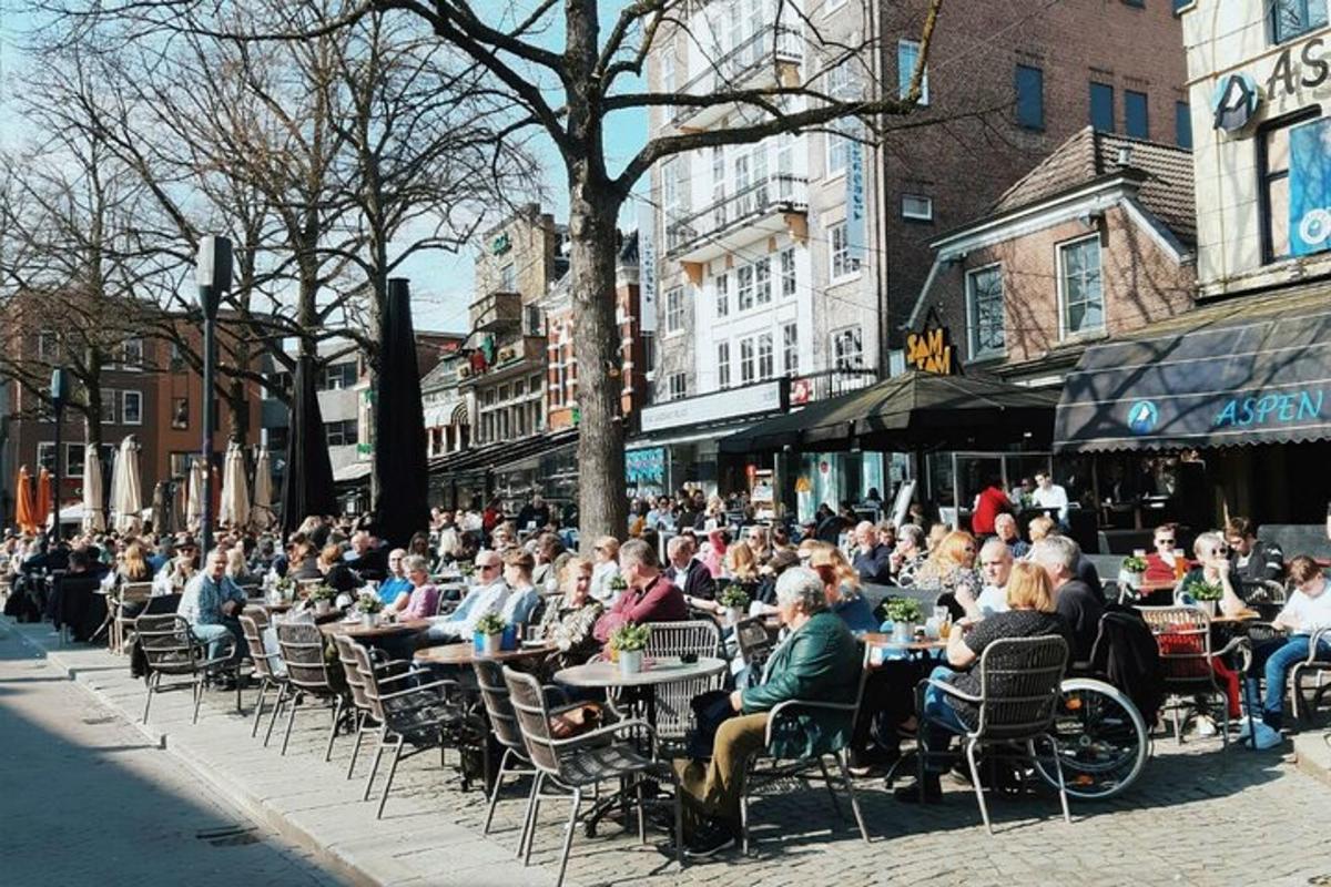 a large crowd of people sitting at tables in a street