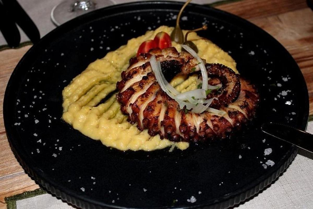 isang itim na plato na may isang piraso ng pagkain sa ibabaw ng pasta
