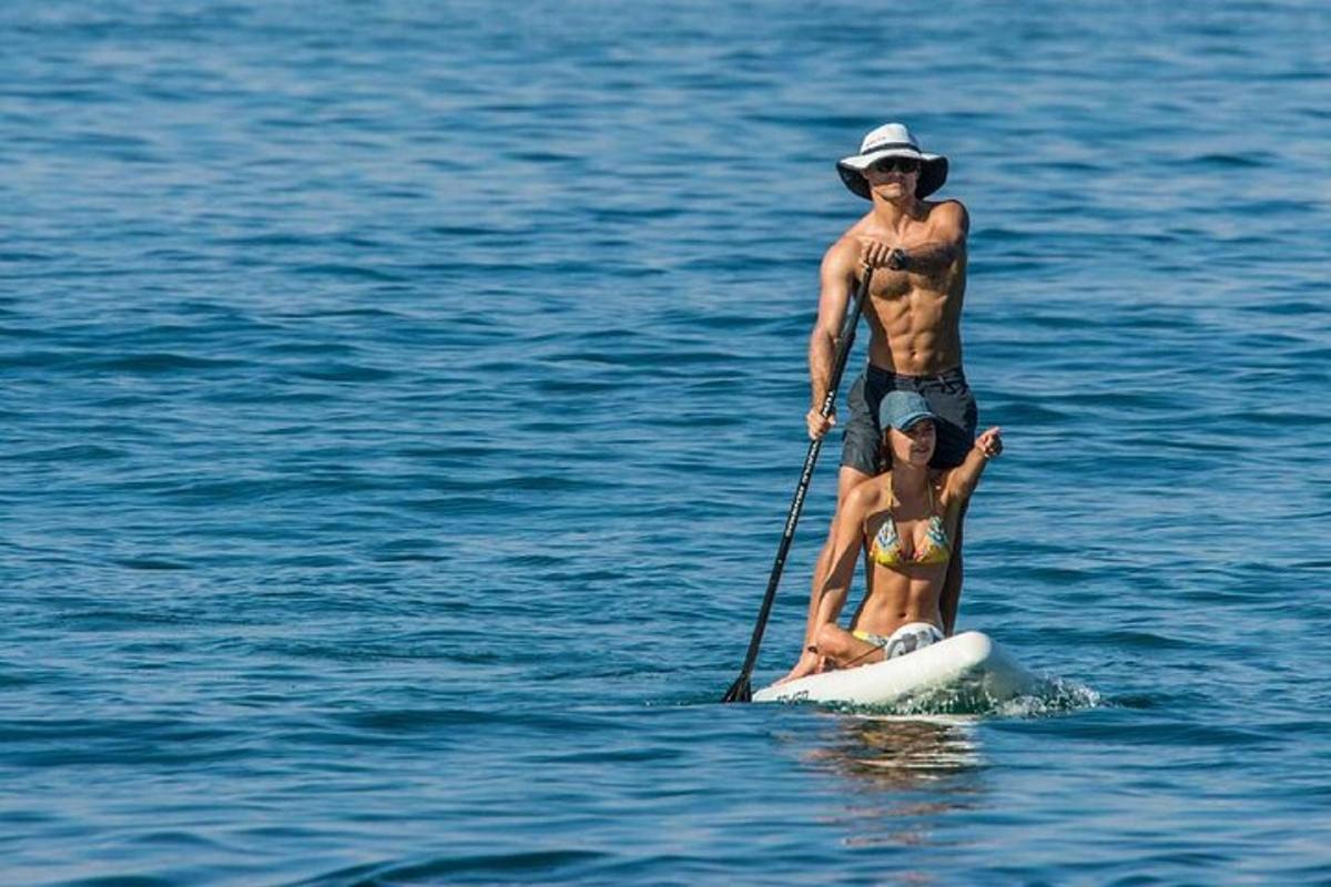 seorang pria dan seorang gadis di papan dayung di dalam air