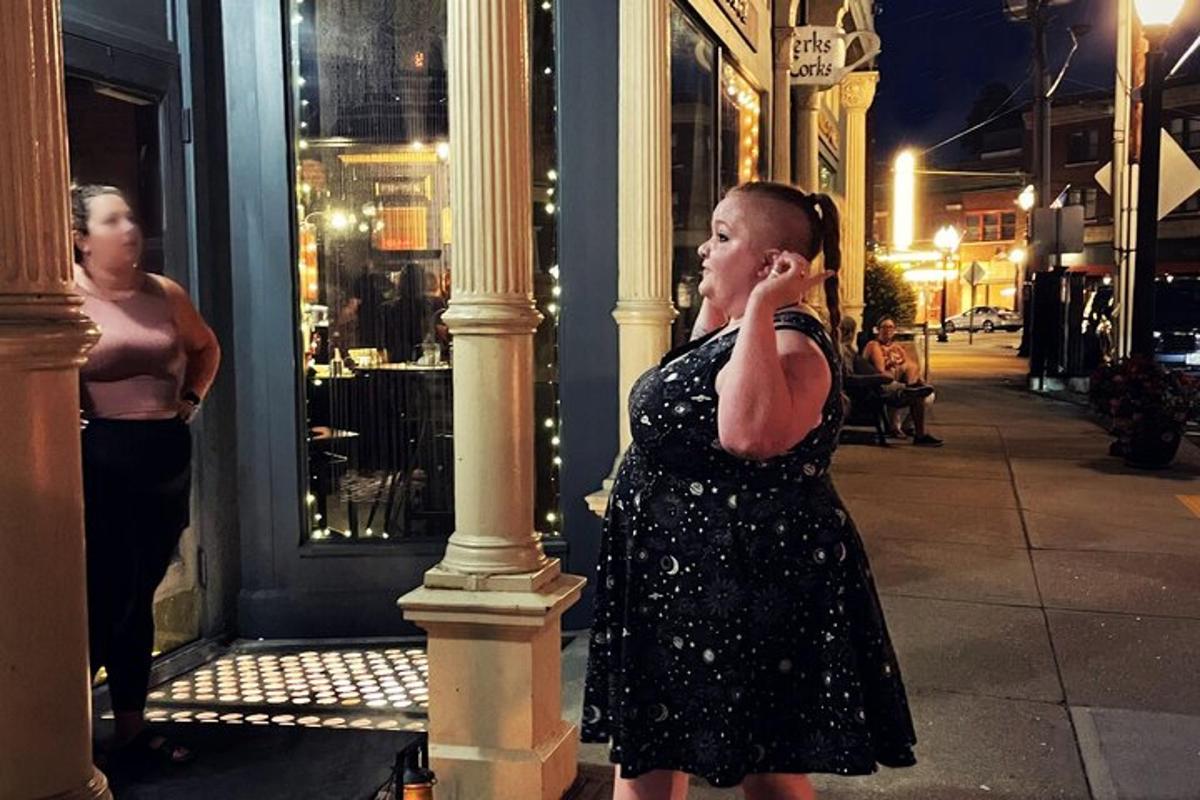 a woman standing on a street talking on a cell phone