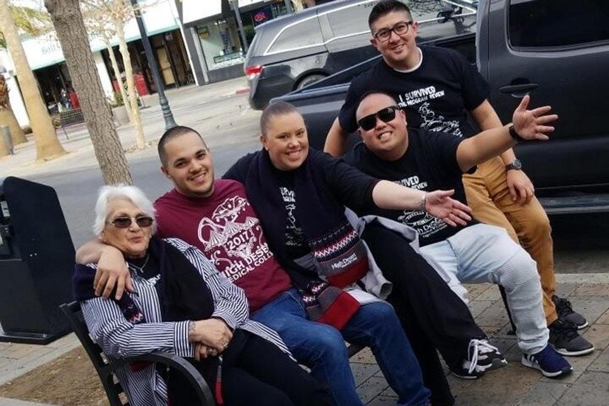 skupina ljudi, ki sedijo na klopi na ulici