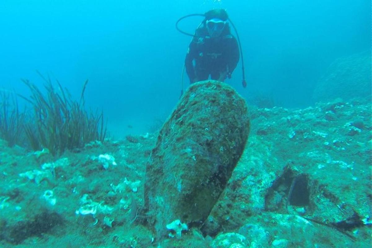 una persona in piedi su una roccia nell'oceano
