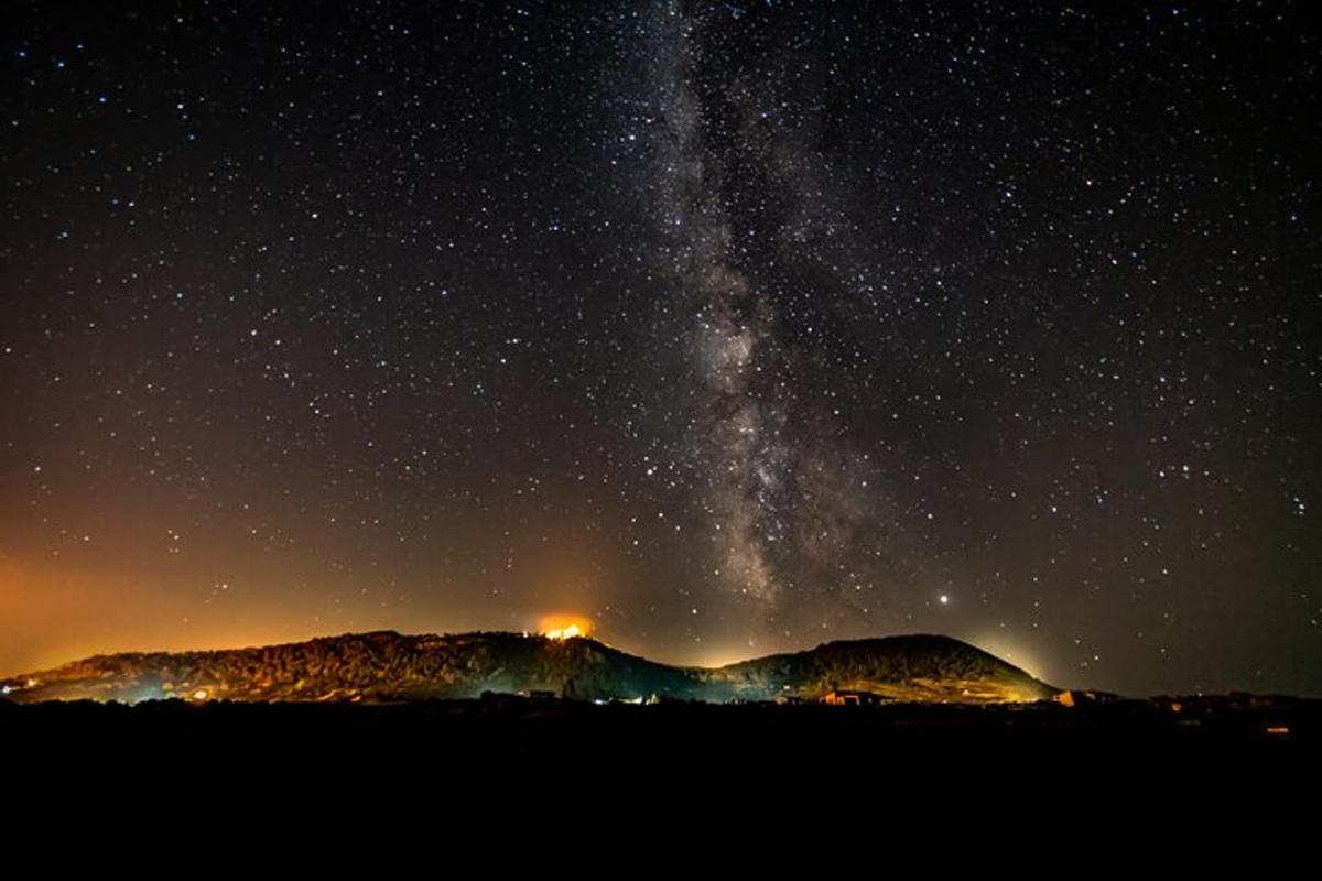 uma noite estrelada com a via láctea sobre uma montanha