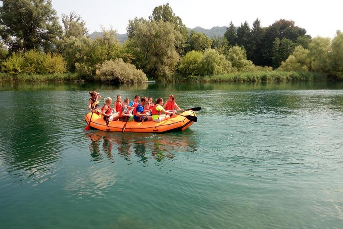 eine Gruppe von Menschen in einem orangefarbenen Boot auf einem See