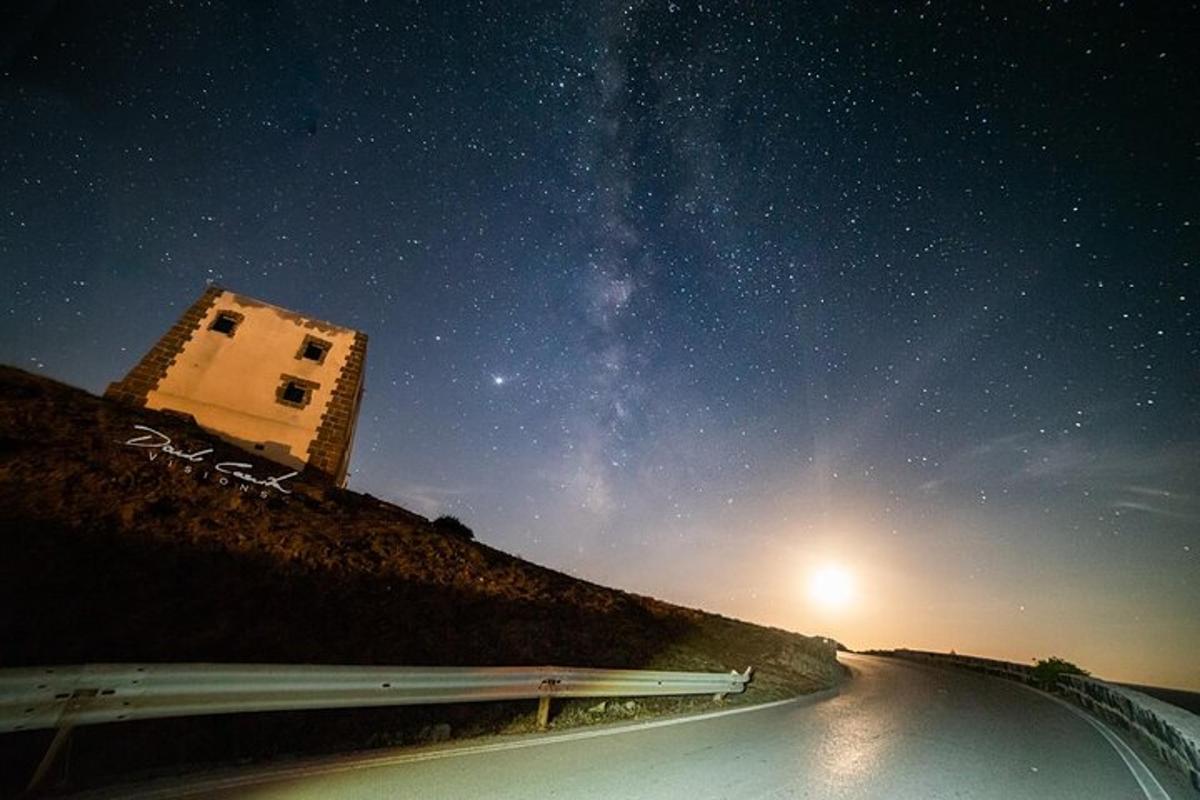 un cotxe circulant per una carretera sota un cel estrellat