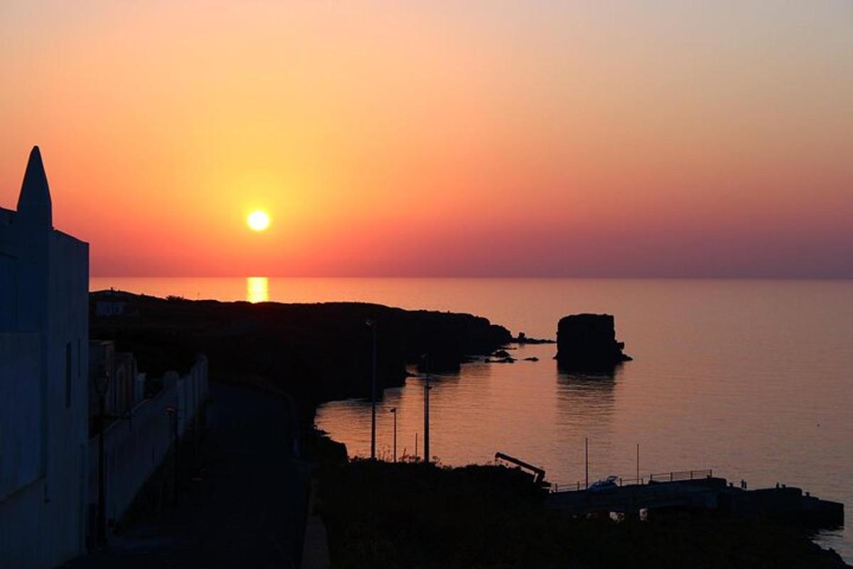una posta de sol sobre una massa d'aigua amb la posta de sol