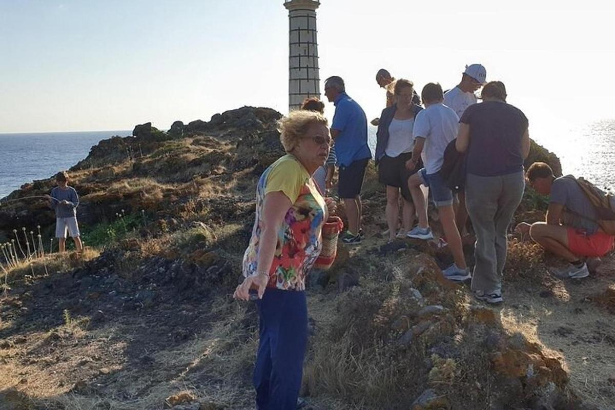 un grup de persones dretes a la vora d'un far
