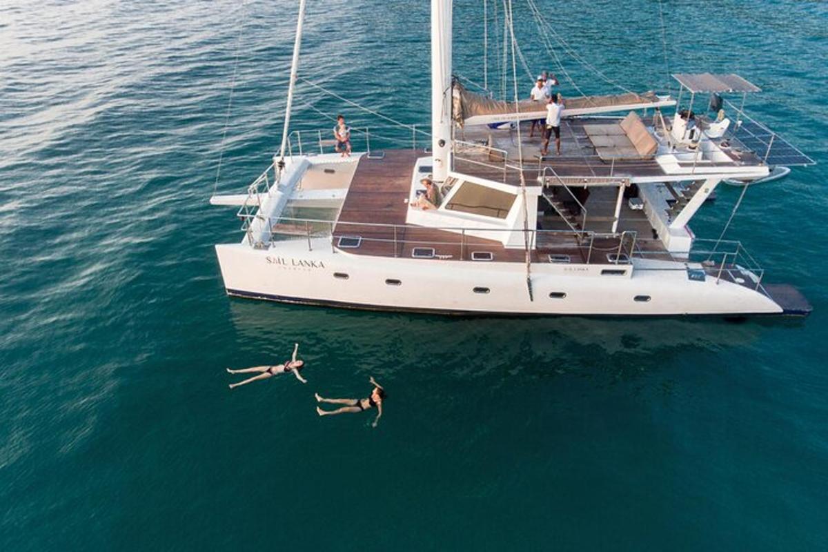 twee mensen zwemmen in het water naast een boot