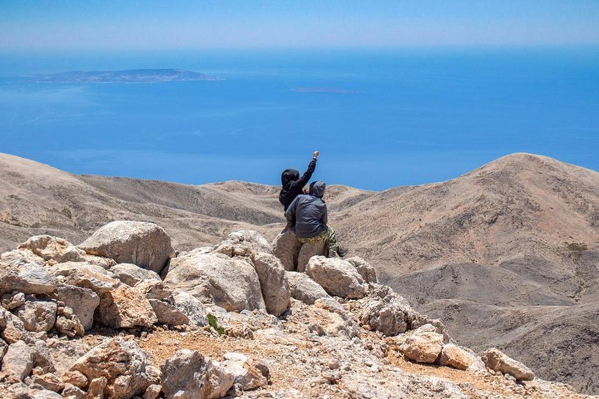Δύο άνθρωποι στέκονται στην κορυφή ενός βραχώδους βουνού