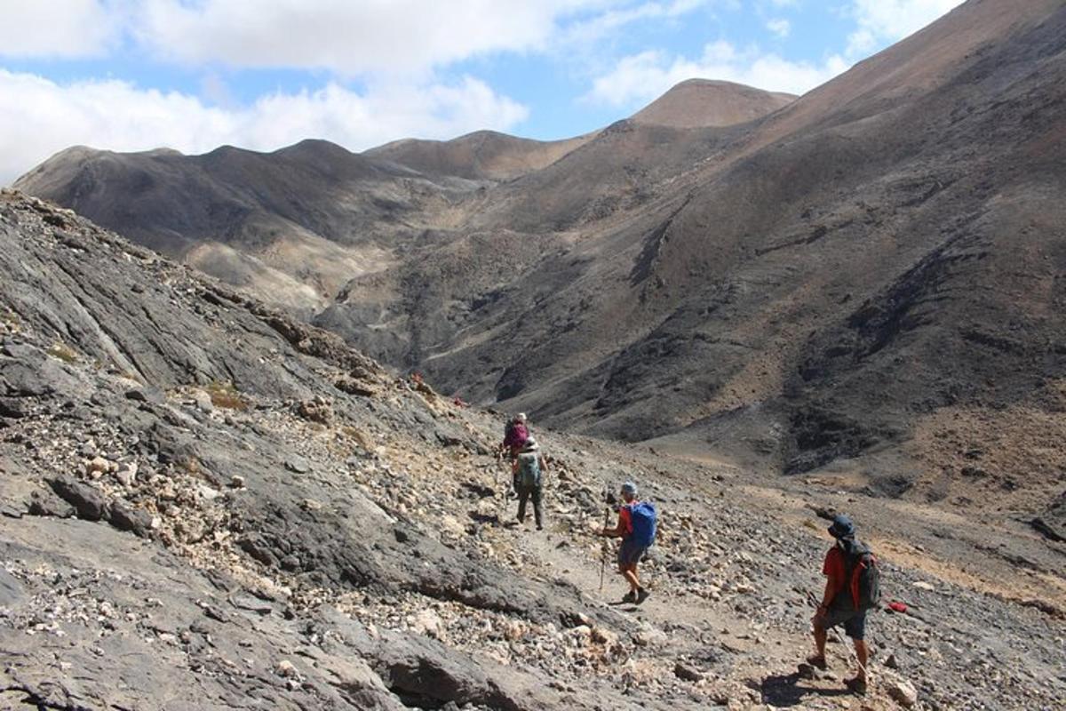 un gruppo di persone che cammina su una montagna rocciosa