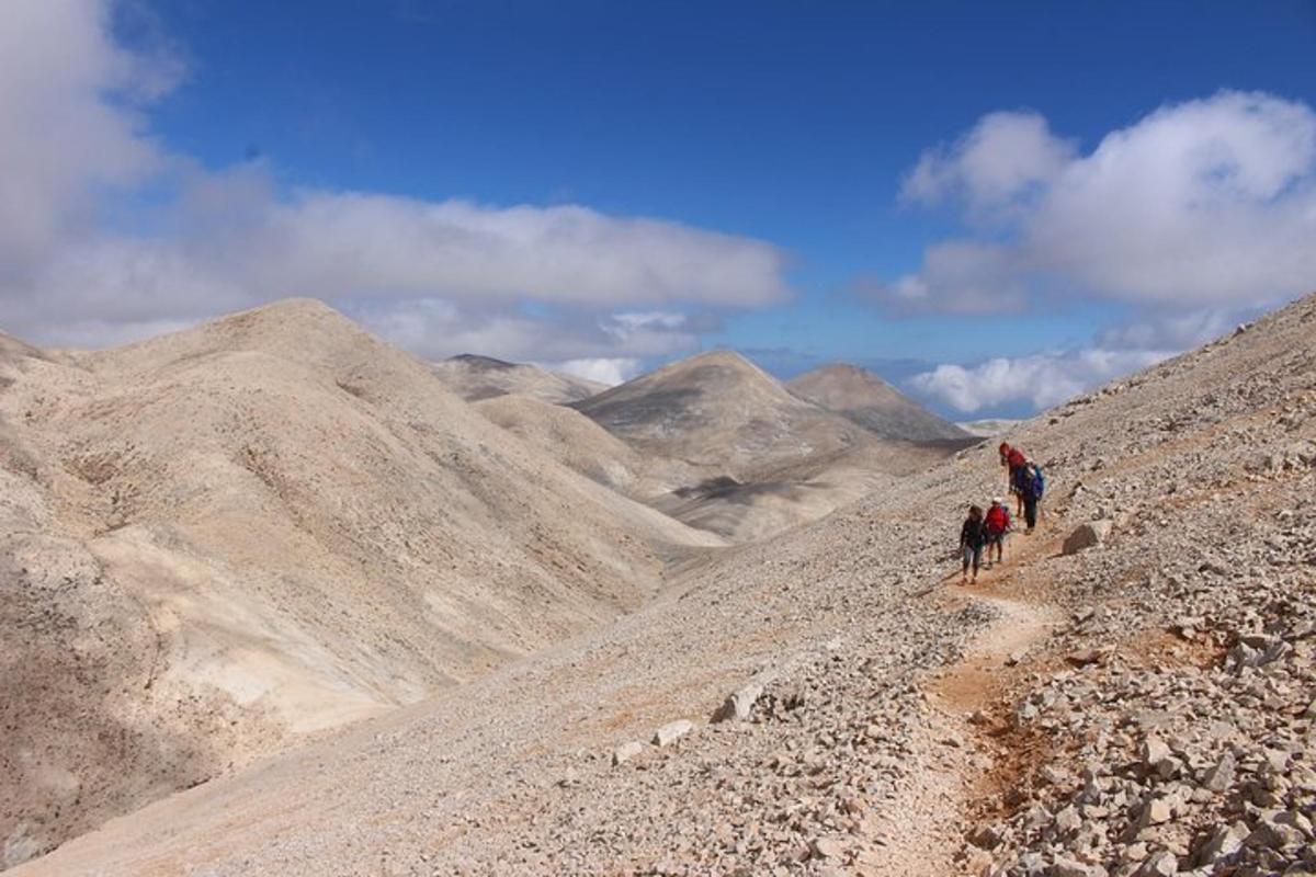 un gruppo di persone che camminano su una montagna rocciosa