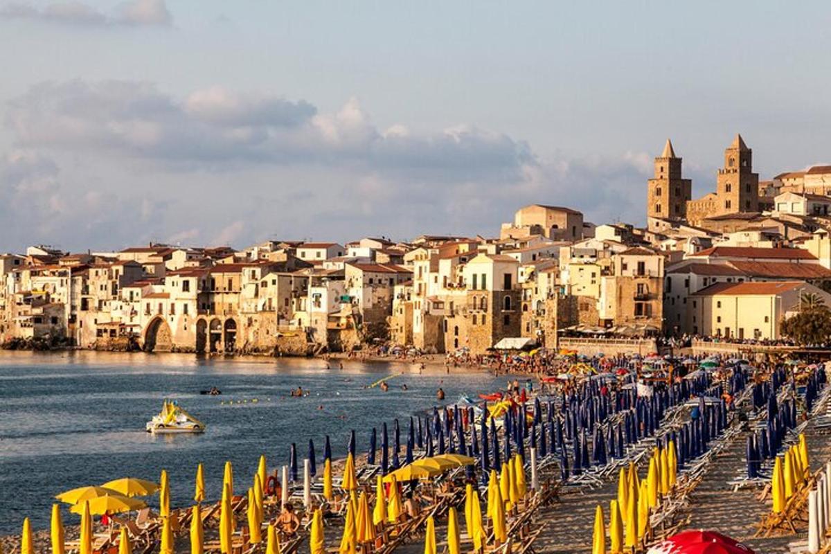 una spiaggia con ombrelloni e persone in acqua