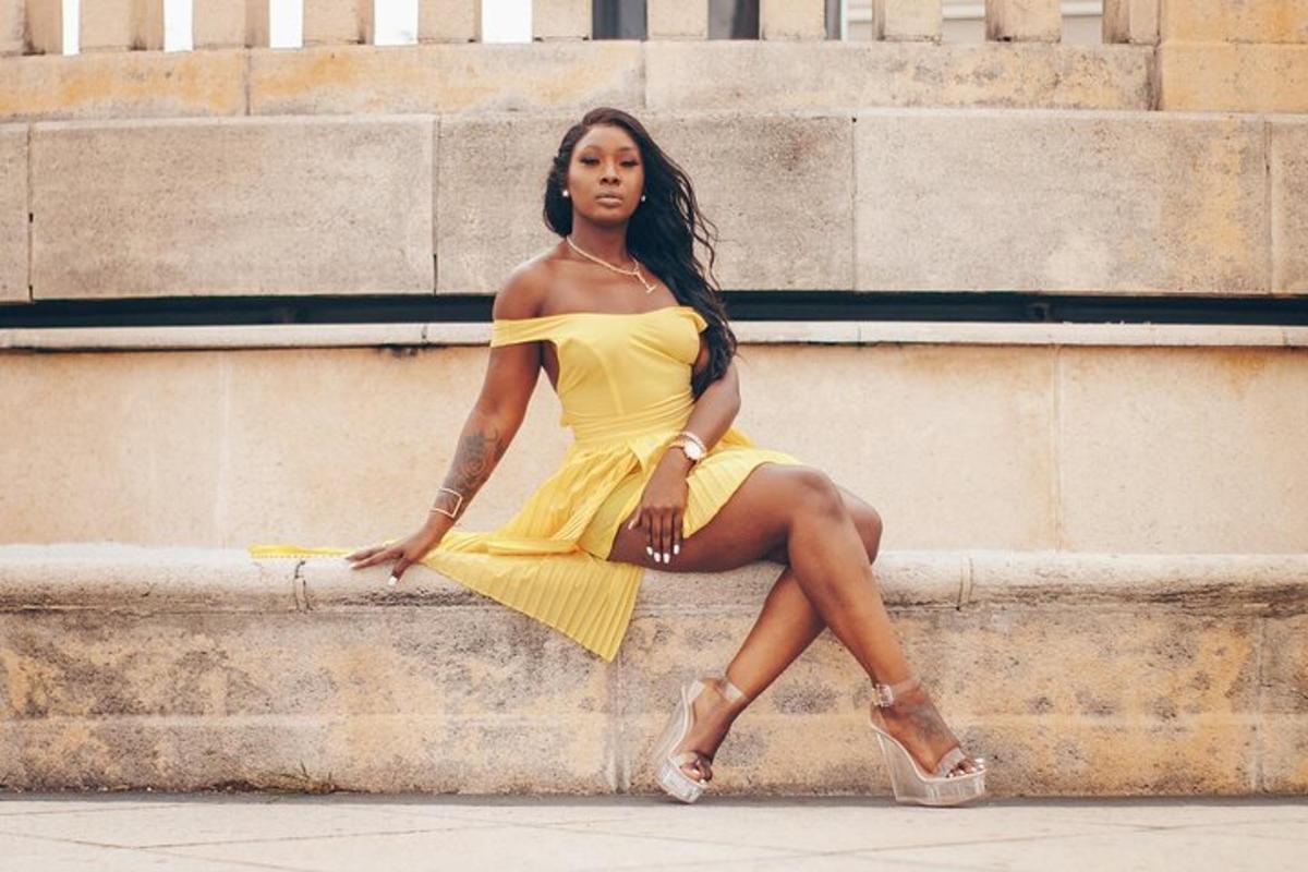 una donna in un vestito giallo seduta su alcuni gradini