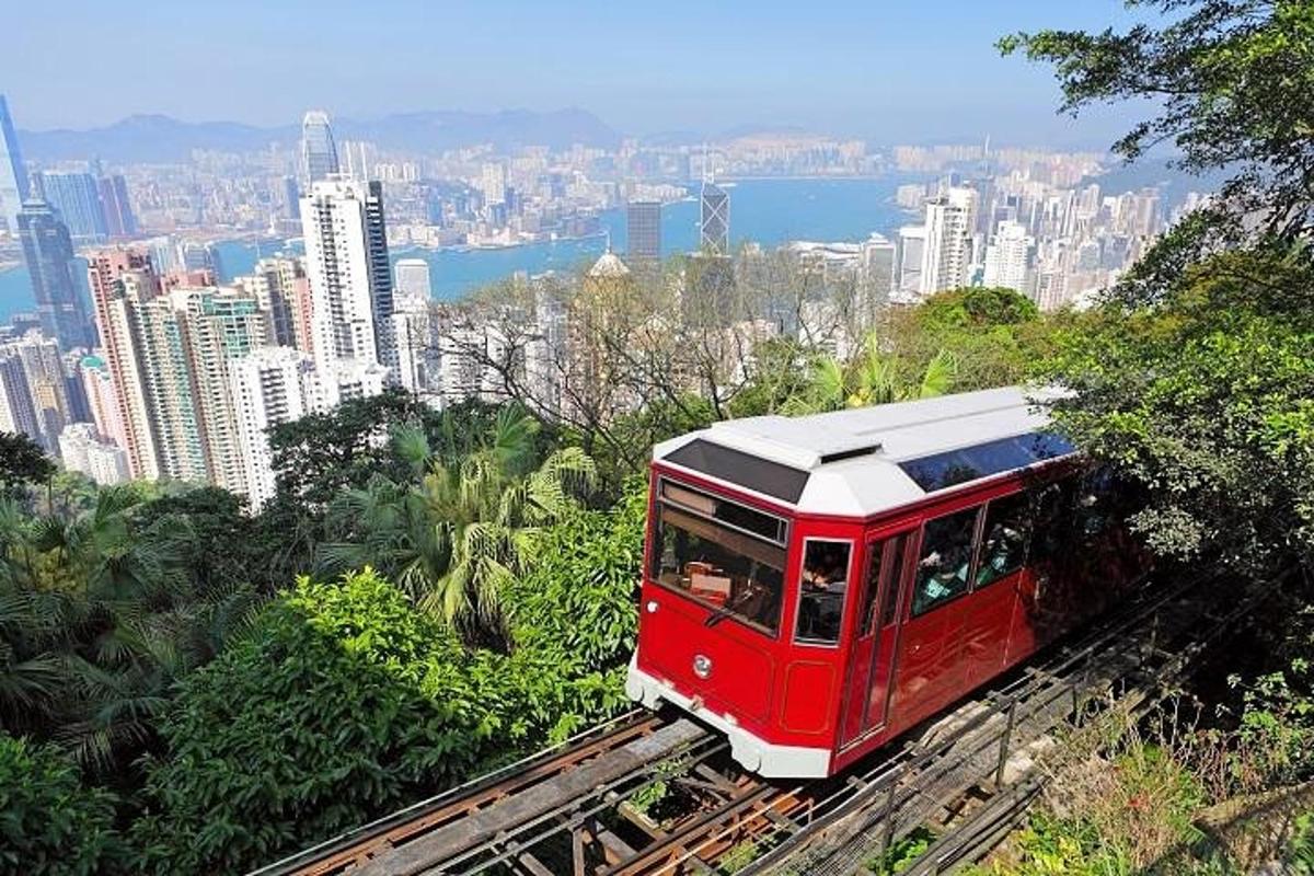 um trem vermelho nos trilhos perto de uma cidade