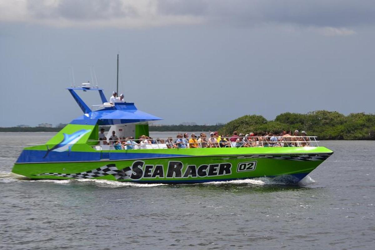 a group of people on a green and blue boat in the water