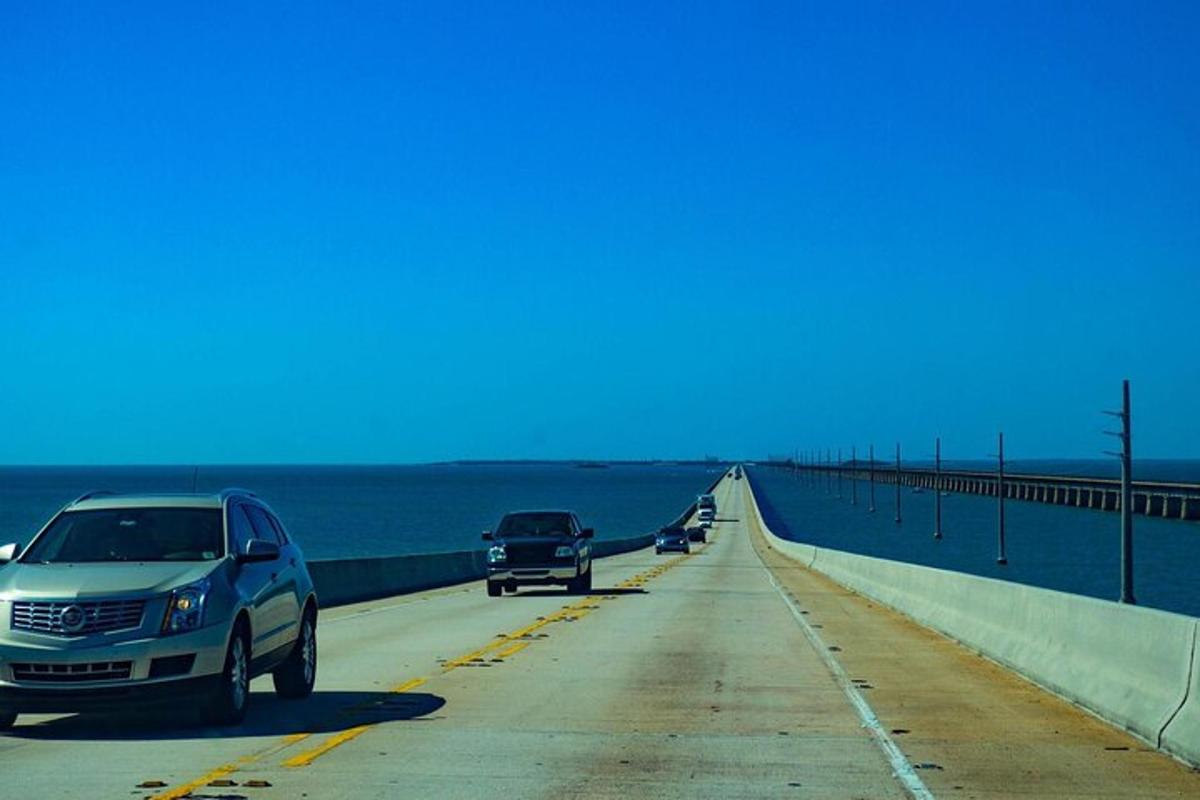 a bridge with cars driving on it next to the ocean