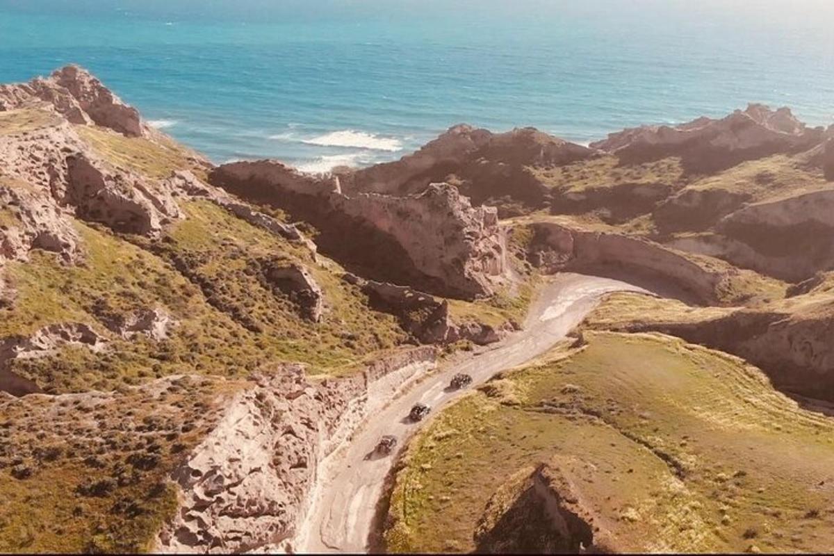 a road on the side of a mountain with the ocean