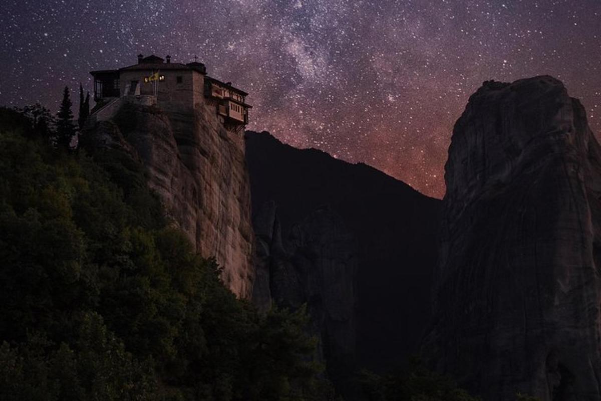 hrad na vrcholu hory pod hvězdnou oblohou