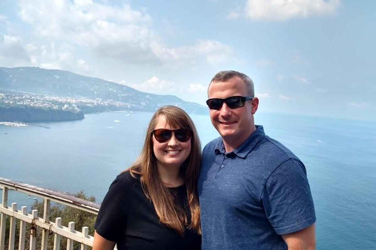 a man and a woman standing in front of the water