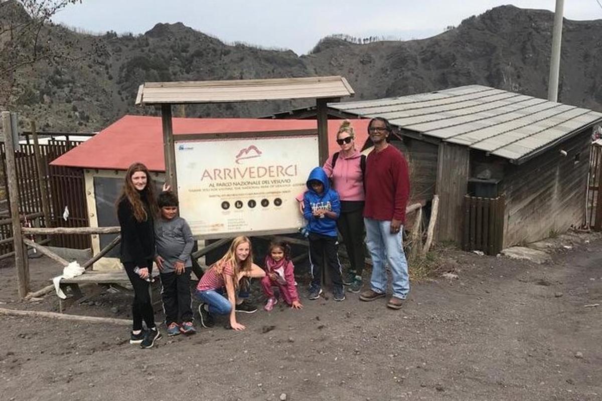 um grupo de pessoas em pé em frente a uma placa