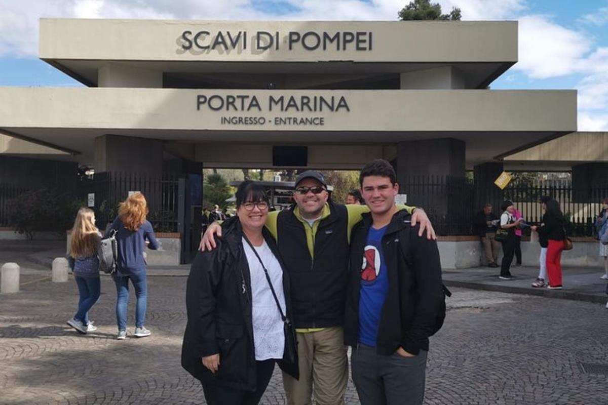 un gruppo di tre persone in piedi davanti a un edificio