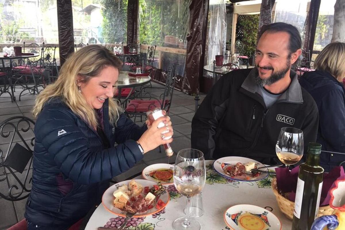 un uomo e una donna seduti a un tavolo che mangiano cibo
