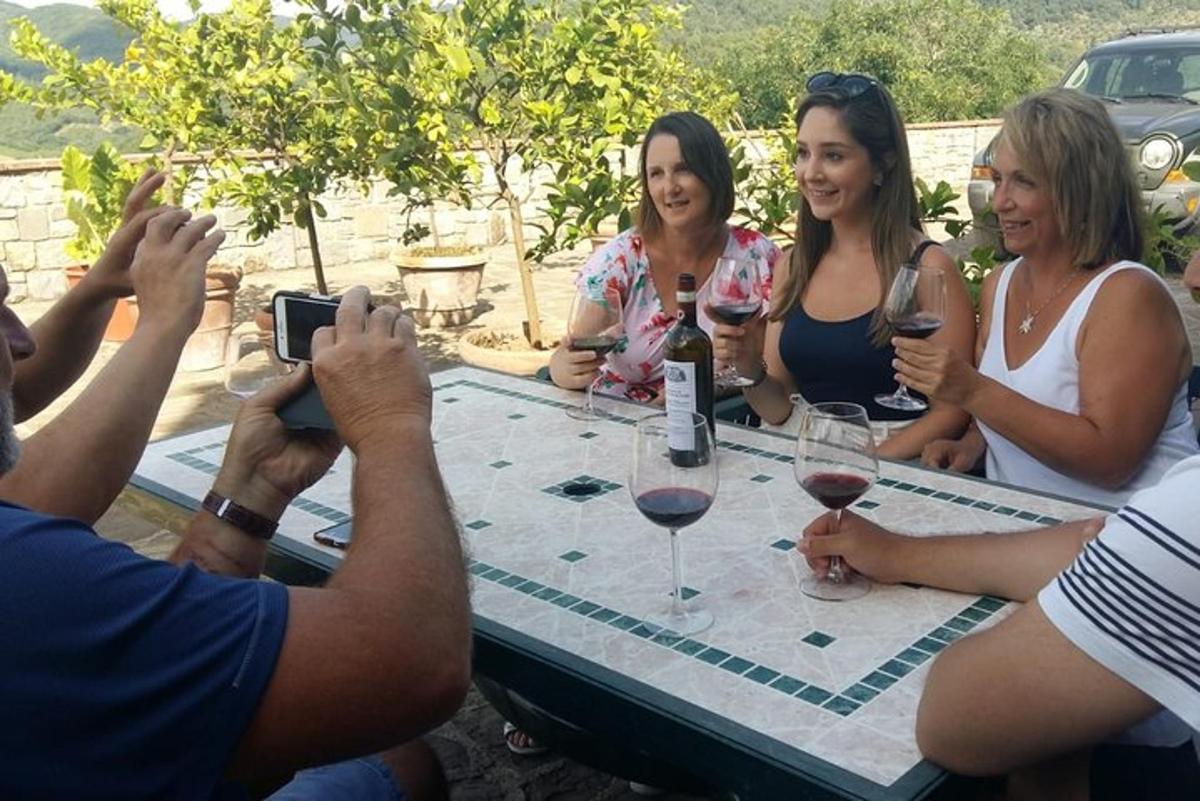 um grupo de pessoas sentadas ao redor de uma mesa com taças de vinho