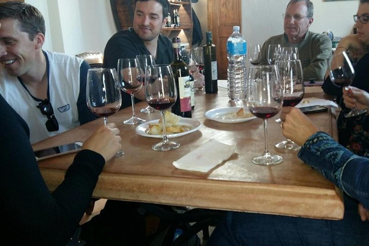 un gruppo di persone sedute attorno a un tavolo con bicchieri di vino