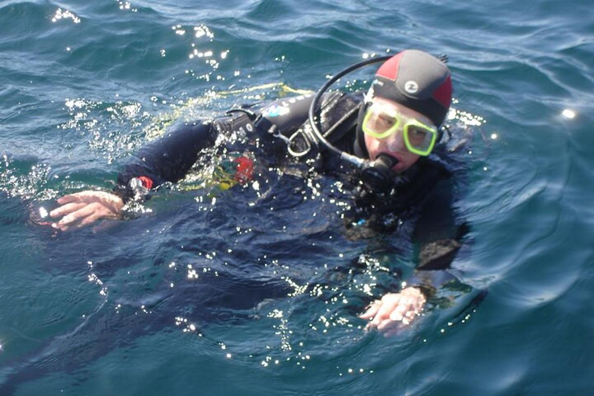 un uomo in acqua con cappello e occhiali da sole
