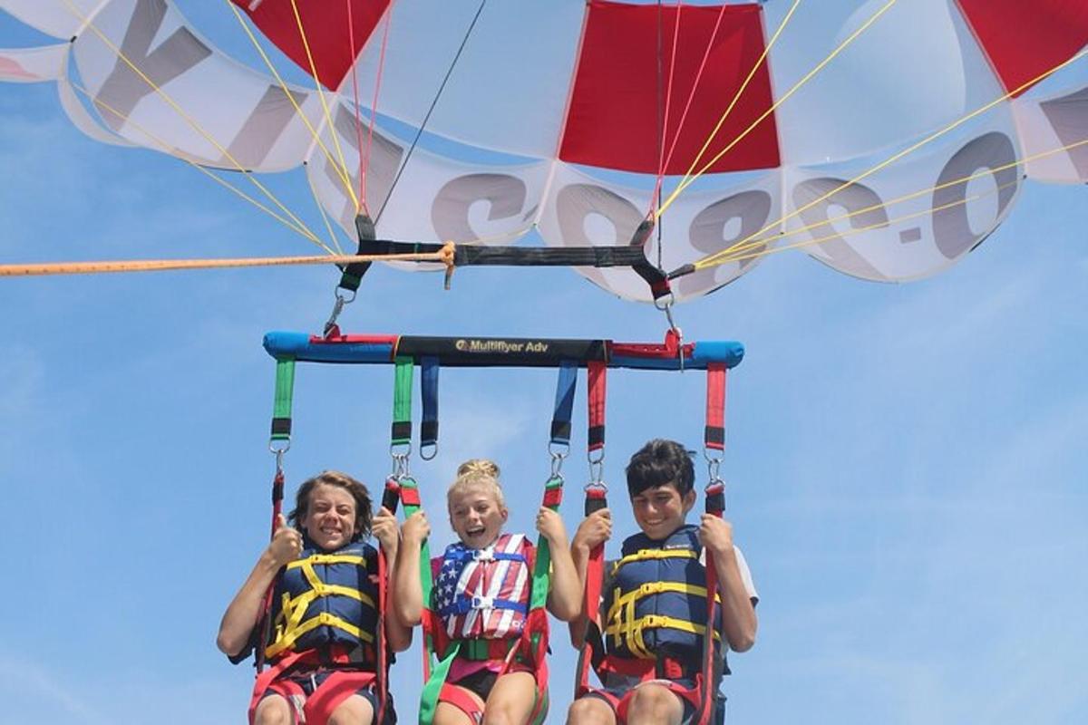 a group of three people riding on a parachute