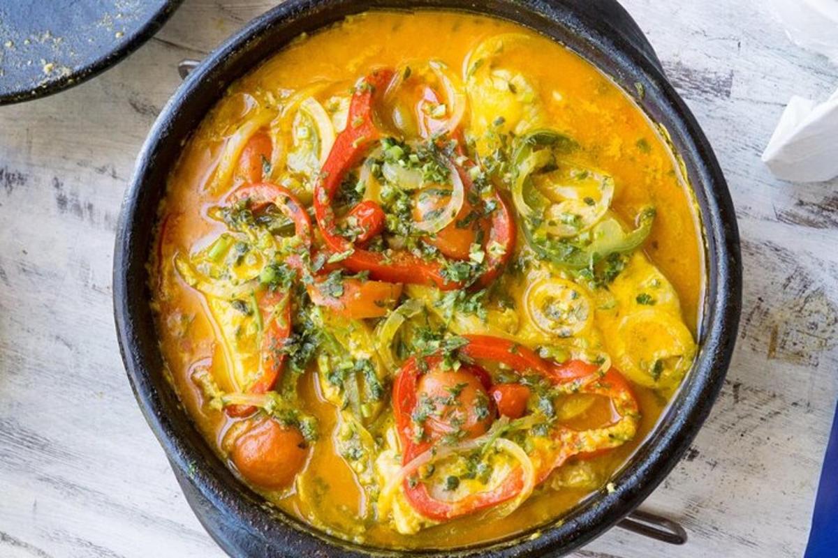 Una olla de sopa con camarones y verduras.