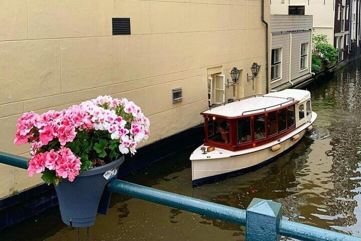 a boat in a canal with flowers in a pot