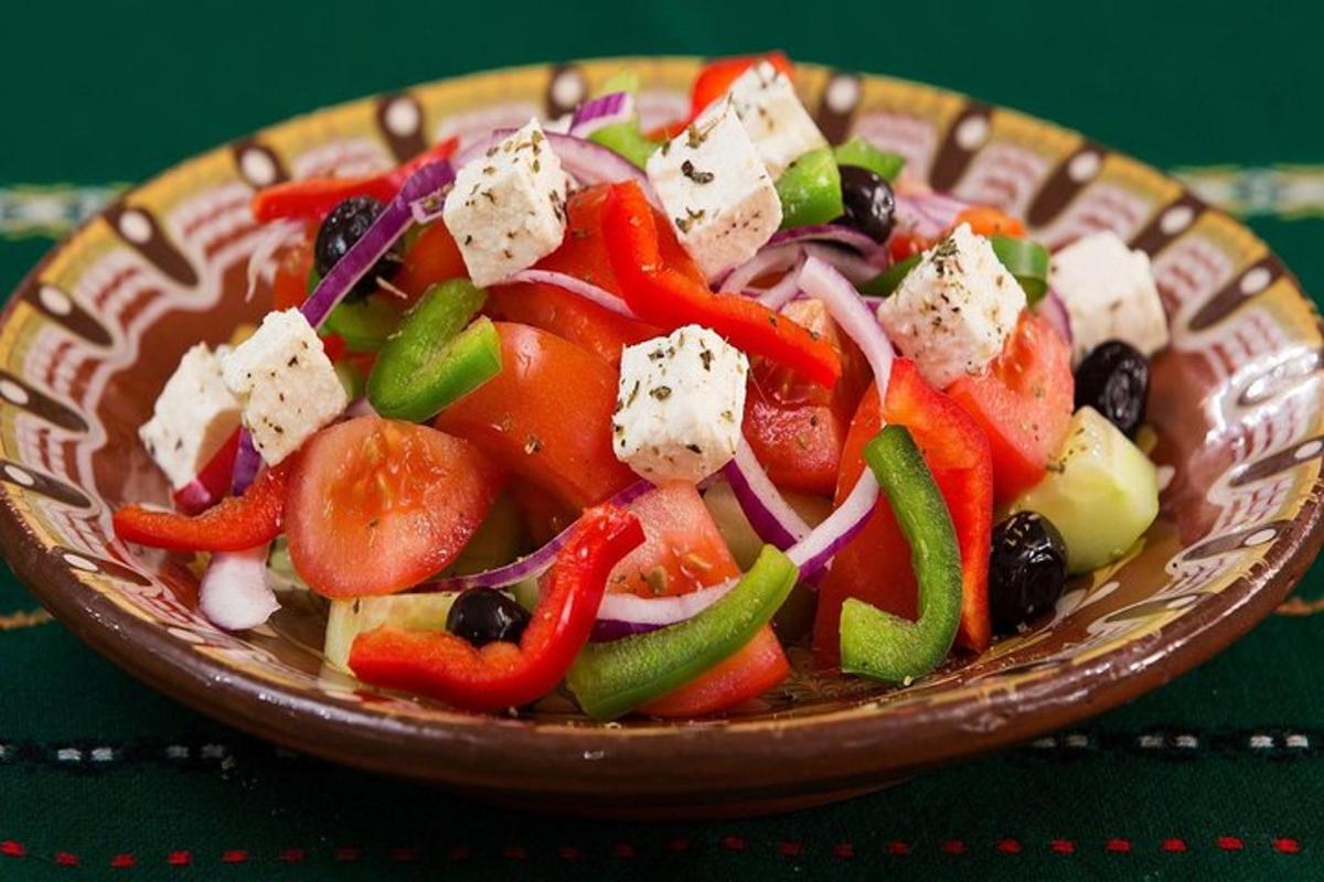 semangkuk salad dengan sayur-sayuran dan keju di atas meja